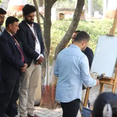 Beginning the landscape painting, with faculty and students observing the initial stages.