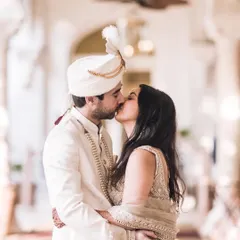 A kiss that seals the promise. This intimate moment between the bride and groom is captured in a beautiful, light-filled hallway, adding to the romance of their wedding day.