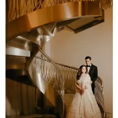 Isht and Paavni posing on a grand spiral staircase in Dubai, a perfect example of a glamorous destination wedding portrait.