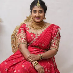 A happy client looking radiant in our red bandhani-style lehenga set. This outfit is a wonderful choice for festive occasions or a pre-wedding celebration, complete with a hand-embroidered blouse.