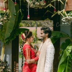 The couple shares an intimate glance. The decor, with its natural elements and soft florals, creates a romantic and sacred atmosphere for the Muhurtham.