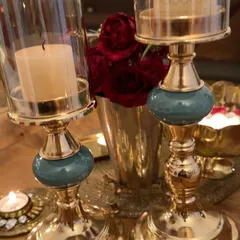 A close-up of the beautiful candle holders. The combination of gold and teal adds a touch of elegance to the festive decor.