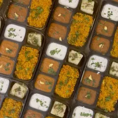 An overhead shot of the meal boxes, showing the delicious Tawa Pulao, Pav Bhaji, and other items packed inside.