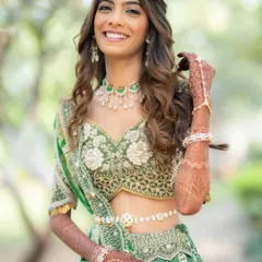 The joy on a bride's face is my biggest reward. For this daytime wedding, we went with a fresh, radiant look with soft, wavy hair that perfectly complemented her beautiful green lehenga.