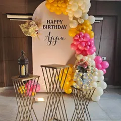 Here's a classic birthday setup with a modern twist. The arched backdrop provides a clean canvas for the custom name and vibrant balloon arrangement, while the geometric pedestals add a contemporary touch.
