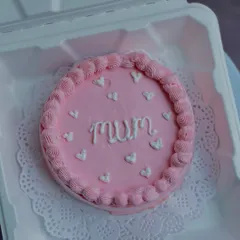 A sweet and simple pink bento cake for "Mum," decorated with tiny white hearts. It's a lovely way to celebrate the superwoman in your life.