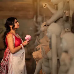 Another frame from the artistic Durga Puja series. The makeup is kept elegant and understated to fit the serene, creative atmosphere of the idol-making workshop, focusing on clean skin and expressive eyes.