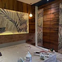 A beautiful mosaic tile panel depicting tropical leaves serves as a stunning headboard feature. This work-in-progress shot shows how we integrate artistic elements directly into the architecture of the room.