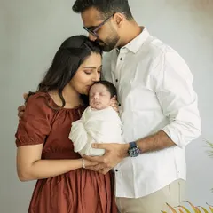 Two hearts became three. A quiet, tender moment as new parents embrace their baby, a memory of the beginning of their greatest adventure together.