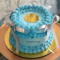 A beautiful example of vintage-style Lambeth piping on a tall cake. The intricate blue scrollwork and delicate ribbons make this chocolate mousse cake a true work of art.