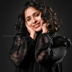 In the studio, it's all about control and precision. For this brand portrait for Annamma Curls, I used a simple dark background and specific lighting to bring out the warmth in her expression and the beautiful texture of her curly hair, creating a clean and engaging image.