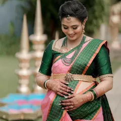 This mom-to-be is glowing during her Seemantha ceremony. I styled her with a lovely green-beaded necklace and a silver-based oddiyanam that sits comfortably and elegantly.