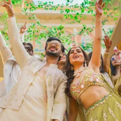 The bride and groom dance with abandon, their hands in the air, during their high-energy Haldi celebration.