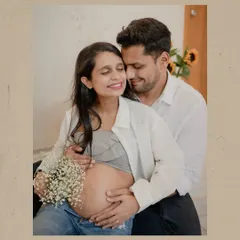 A warm and tender moment between the parents-to-be. The use of simple props like a bouquet of flowers adds a soft, romantic touch to the maternity couple portraits.