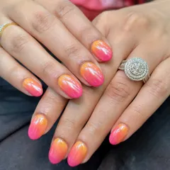 I am obsessed with this vibrant ombre look. We blended a sunset orange and a bright pink gel polish and then finished it with a chrome powder to give it that incredible, eye-catching sheen.