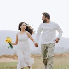A shot full of life and happiness. The couple running hand-in-hand through a field, with a bouquet of sunflowers, captures the pure joy of being in love.