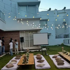 An overview of our outdoor movie night setup in a backyard, complete with a projector screen and low seating for a cozy viewing experience.