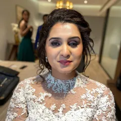 A close-up portrait of the bride, looking serene and beautiful. The makeup is subtle, with a focus on glowing skin and defined eyes.