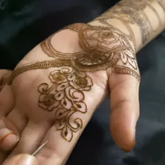 A close-up of me working on a delicate rose pattern in the palm. The fine lines and careful application are key to achieving this soft and romantic floral look.