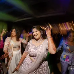The bride and her friends dancing their hearts out. The colorful lights and motion blur convey the excitement of the party.
