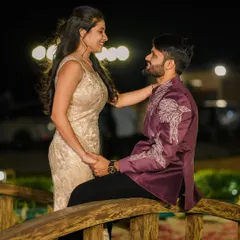This romantic shot showcases a custom-designed Indo-Western jacket for a groom-to-be. The rich plum color and the unique, wing-like silver embroidery on the shoulder make it a standout piece for a proposal or engagement.