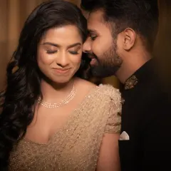 A quiet moment of intimacy during a reception photoshoot. The soft lighting and close crop focus entirely on the couple's connection.
