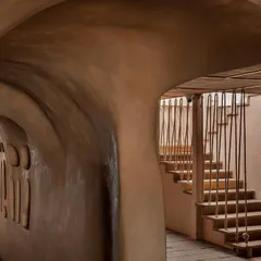 Another view of the staircase and cave-like corridor at Dubki. The organic shapes and textured walls were designed to create a unique sensory experience, making the journey through the space as important as the destination.