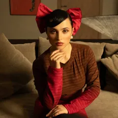A quirky and stylish portrait with a bold red bow. This shows versatility and the ability to create memorable, character-driven fashion images.
