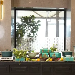 A modern buffet station with a focus on fresh, green elements. We use unique serving dishes and natural decor to elevate the buffet experience, integrating it seamlessly with the event's overall aesthetic.