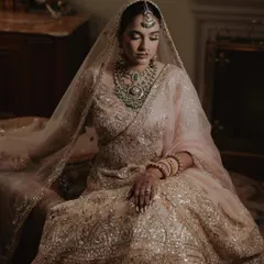 A quiet, regal portrait of the bride Sanskriti, seated in her glittering Manish Malhotra lehenga at the Rambagh Palace in Jaipur.