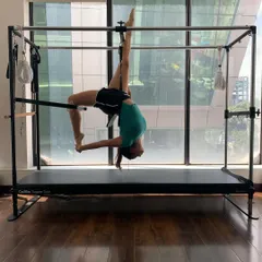 An advanced inverted pose on the Cadillac. Please only attempt movements like this under the guidance of a professional trainer to ensure safety.