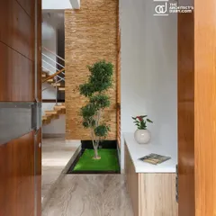 The entrance to the Cube House opens to a small internal courtyard with a single tree under a skylight. This acts as a buffer, immediately introducing natural light and a sense of calm.