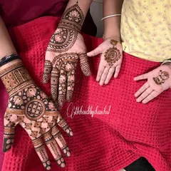 Mehendi for the whole family! Here you can see the mom's intricate design next to her daughter's tiny hands with a simple mandala and a cartoon character.