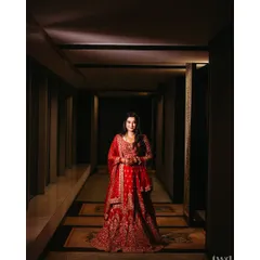 Draped in red, glowing with elegance. This portrait captures the bride's regal reception look in a beautifully lit hotel corridor, making her look like royalty.