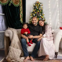 A full family portrait showcasing their relaxed and happy bond. Christmas photoshoots are a wonderful tradition to capture your family's growth each year.