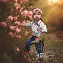 A charming outdoor portrait of a little boy interacting with a bush of pink roses. I encourage kids to explore their surroundings, which leads to natural and candid photographs.