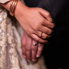 A close-up shot of the couple's hands, showcasing their newly exchanged engagement rings. A simple, powerful symbol of their commitment.
