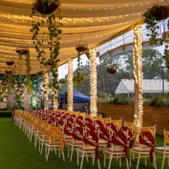 The aisle of our Sky Terrace is ready for a grand entrance, lined with chairs and illuminated by fairy lights, leading to a beautifully decorated stage.