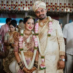 A classic wedding portrait. The bride's soft pink and white saree is complemented by the groom's custom cream sherwani, showcasing how I coordinate colors and embroidery for the perfect pair.