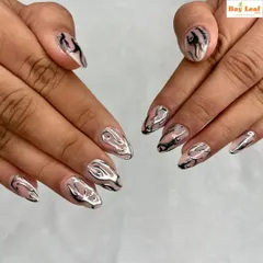 A futuristic and edgy design. These almond-shaped nails feature a clear base with 3D liquid silver chrome art, creating a stunning, abstract metallic effect.