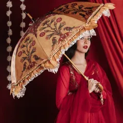 This image showcases another designer umbrella from the same collection, demonstrating the variety within the product line. The model's pose and gaze create a sense of elegance and storytelling, turning a product shot into a captivating portrait.