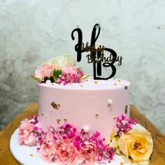 A beautiful pink birthday cake adorned with a mix of fresh pink carnations, roses, and baby's breath for a soft, romantic look.