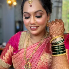 This portrait showcases the complete look for Snehal's Tamil wedding. The burgundy brown eyes are the star, beautifully complementing her pink silk saree and traditional jewelry.