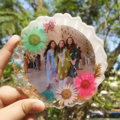 Here is the same floral photo frame design, held up against a natural background to show how the colors of the flowers pop. It's a wonderful way to frame a memory with the beauty of nature.