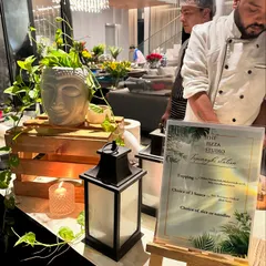 Our live Teppanyaki station, set up for a house party. The station is decorated with a Buddha head planter and lanterns, with a menu detailing the choices of sauces and rice or noodles for guests.