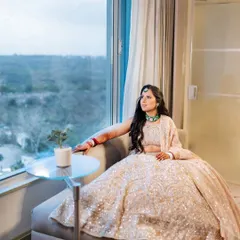 A pensive bridal portrait, with the bride looking out a large window, creating a beautiful, thoughtful moment before her wedding.
