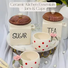 A new addition to our collection: charming ceramic kitchen essentials. This set includes "Sugar" and "Tea" jars with wooden lids, and adorable red polka-dot mugs with pink rose handles.