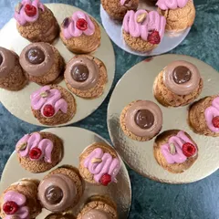 A close-up of my favorite choux pastries. I offer them in several flavors, including the rich Chocolate & Caramel and the fresh, vibrant Pistachio & Raspberry. Each one is a little bite of heaven.