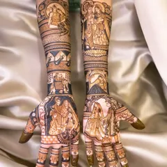 This intricate design tells a complete story across both arms, with portraits of Radha-Krishna, the couple, their family, and even a depiction of a meaningful place. Every part of this mehndi is filled with personal details.