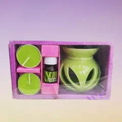 This is a complete aromatherapy set, which includes a green ceramic oil diffuser, two tealight candles, and a bottle of lemongrass aroma oil. It's a perfect starter kit for home fragrance.